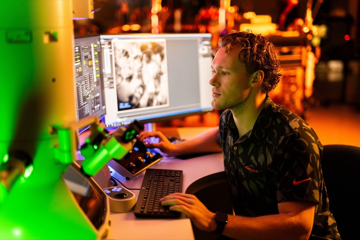 A student works at a research workstation in a UT lab